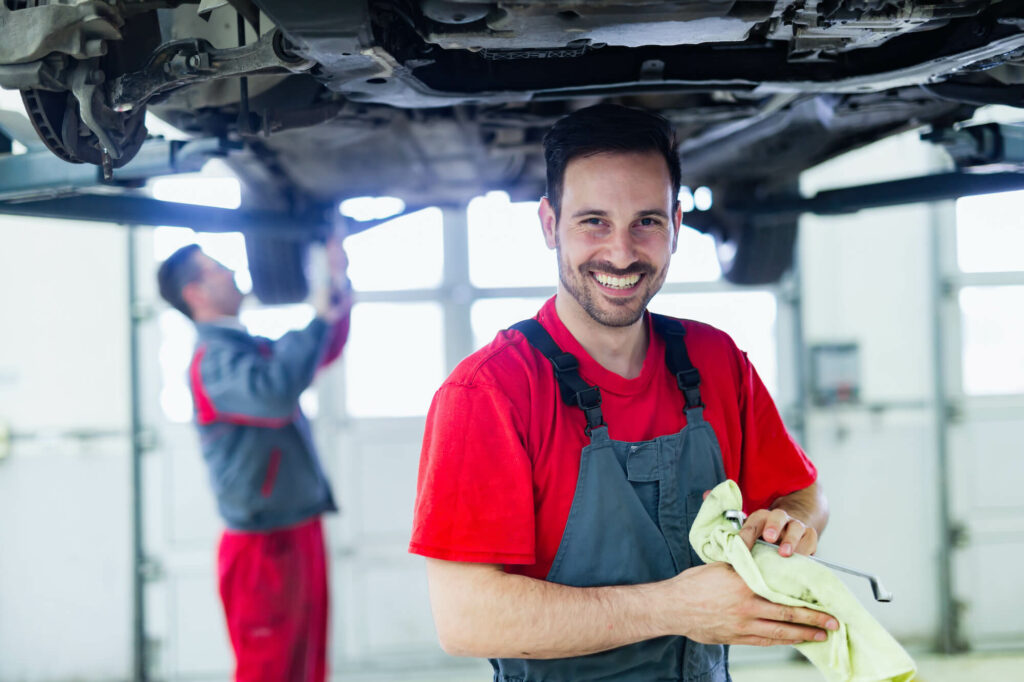 car service technician smilling wiping off hands