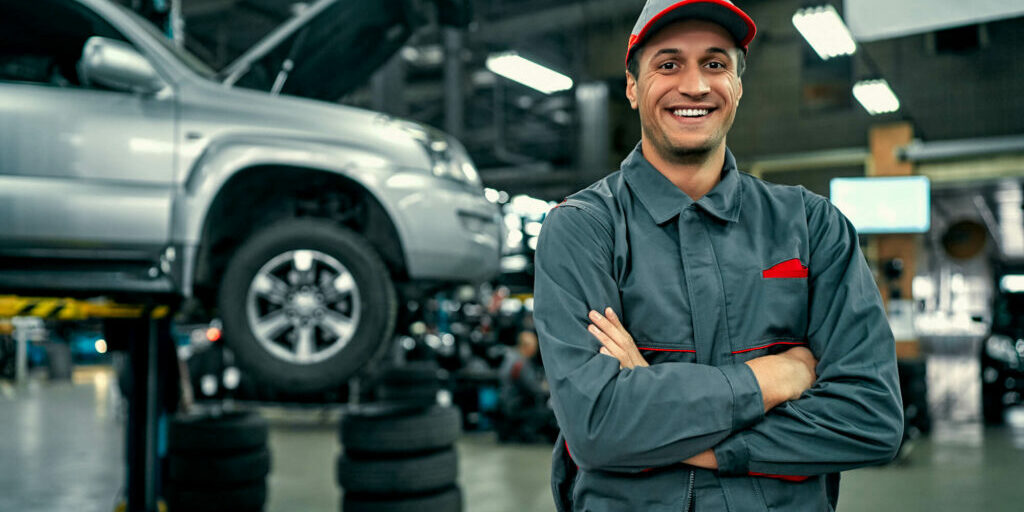 car service technician smiling with arms folded