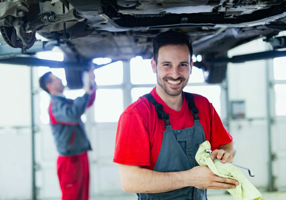 car service technician smilling wiping off hands car service technician smilling wiping off hands