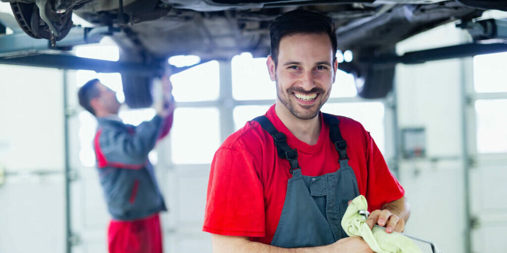 car service technician smilling wiping off hands